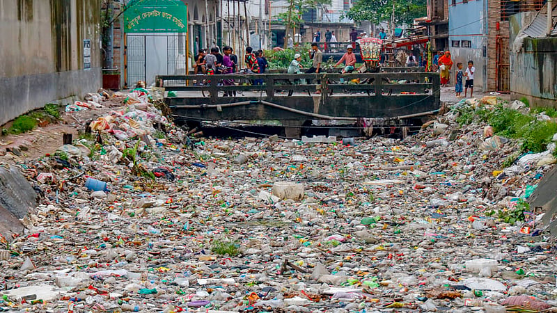 The water level of the canal rose due to a spell of persistent rain in Dhaka over the past several days, causing plastic garbage to pile up along its sides and on the path.  Photo: Mahmud Zaman Ovi