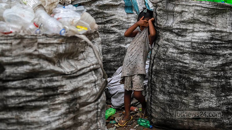 Turna, a girl who gave a single name, plays in a pile of plastic bottles at a recycling plant where her mother works in Dhaka’s Hazaribagh.  Photo: Tawhiduzzaman Tapu