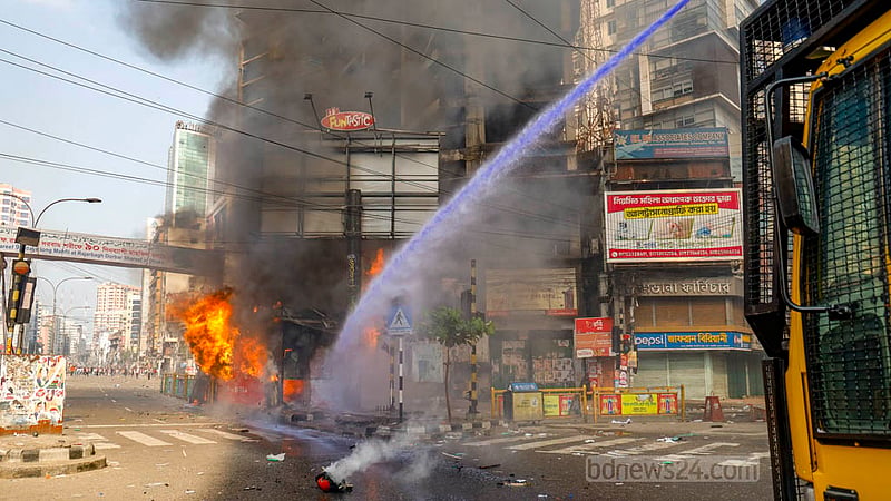 Police officers try to douse a fire burning a police box by using a water cannon in Dhaka’s Kakrail amid violent clashes with BNP activists during their Naya Paltan rally on Saturday, Oct 28, 2023.
