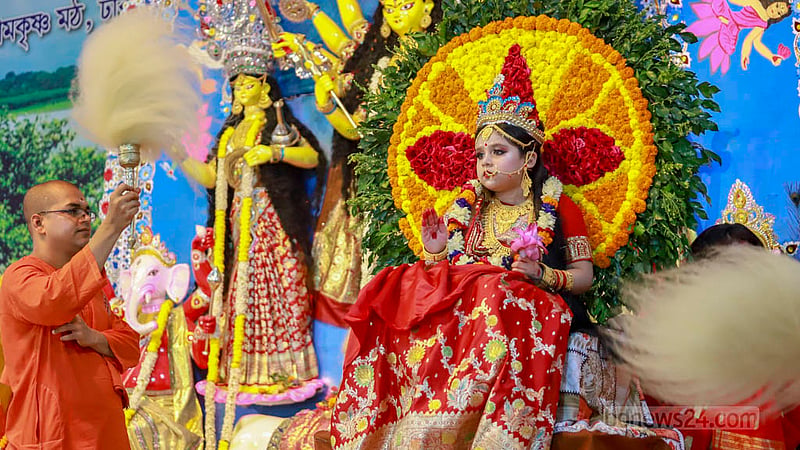 A priest fans Shatakshi Goswami, a 5-year-old girl, as she is dressed up for being worshiped as part of Kumari Puja on the morning of Sharadiya Durga Puja’s Maha Ashtami at Ramakrishna Mission in Dhaka on Sunday, Oct 22, 2023. Photo: Tawhiduzzaman Tapu