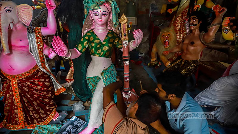 Artisans drape an idol in a traditional saree at a temple in Dhaka's Banglabazar in preparation for Durga Puja. 
Photo: Twhiduzzaman Tapu