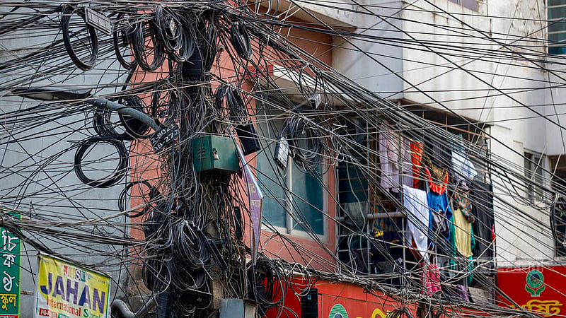 An electrical pole in South Banasree is covered by internet and cable TV wires. The cables close to the second floor of a building put those standing on the balcony at risk. Photo: Mahmud Zaman Ovi