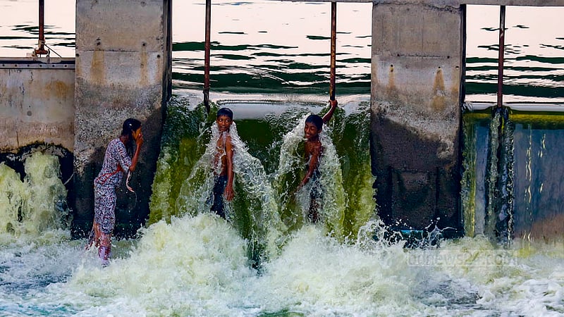 Children play in the water flowing through the switch gate in Hatirjheel’s Rampura Bridge section on Friday, Nov 20, 2023.