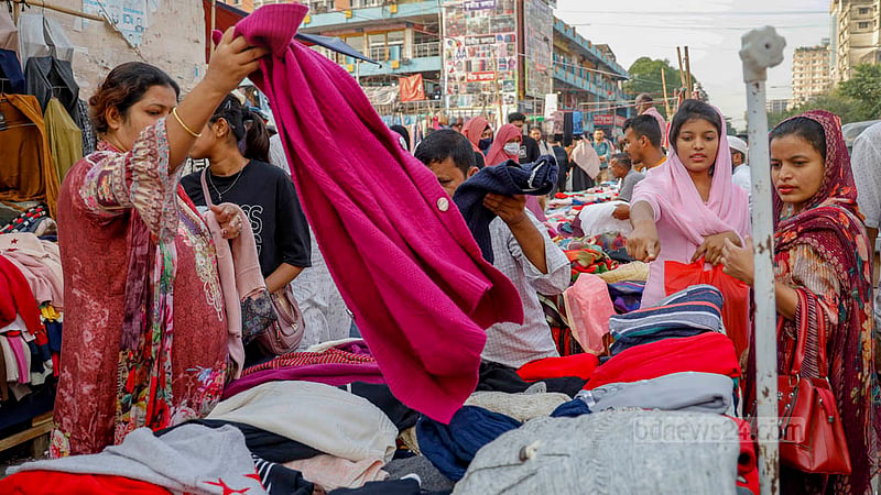 Women pick out winter clothes to buy from the footpath outside the New Market. Photo: Mahmud Zaman Ovi