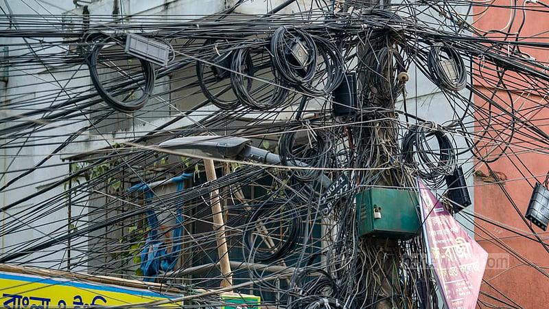 The internet and satellite cables are dangerously tangled in front of homes in the streets of South Banasree residential area. Photo: Mahmud Zaman Ovi