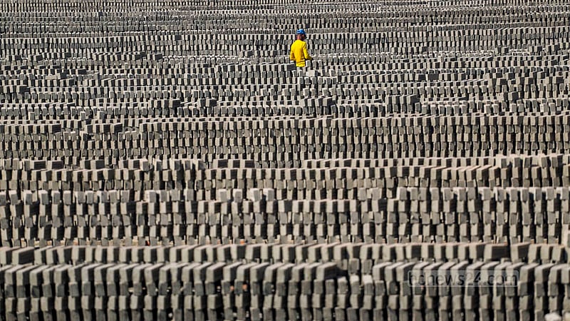 A worker stacks unburnt bricks for burning in a kiln near the Buriganga River in Dhaka’s Basila. Photo: Tawhiduzzaman Tapu