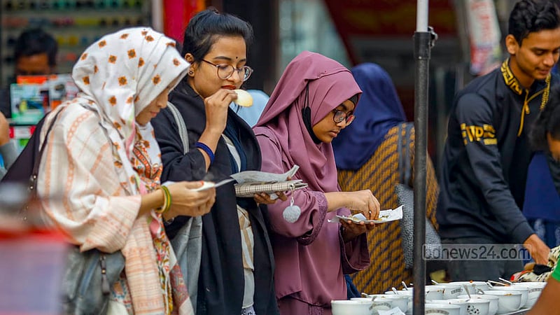 Young women enjoy Chitoi Pitha at a street food shop in Dhaka’s Farmgate.