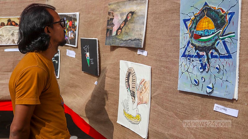 A visitor appreciates paintings at an exhibition in the TSC area of Dhaka University on Tuesday, Dec 12, 2023, to protest against Israel’s attack on Palestine.