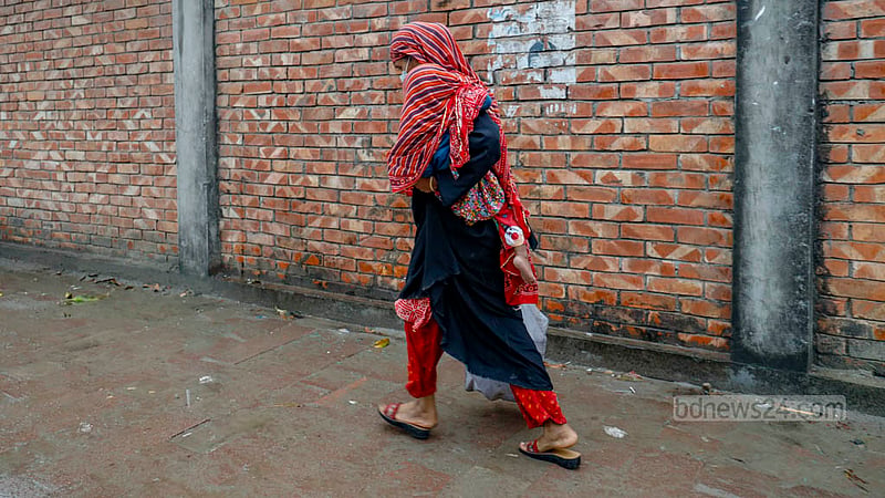 A woman carrying her child buys goods from a TCB truck after waiting a several-hour wait in the rain on Thursday, Dec 7, 2023.