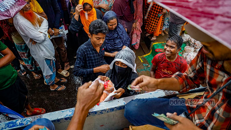A child buys goods from a TCB truck amid the rain at Hatirjheel’s Madhubagh section on Thursday, Dec 7, 2023.