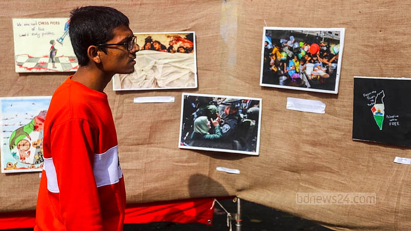 A visitor appreciates paintings at an exhibition in the TSC area of Dhaka University on Tuesday, Dec 12, 2023, to protest against Israel’s attack on Palestine.
