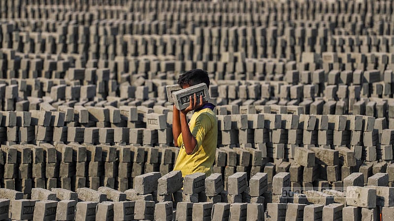A worker stacks unburnt bricks for burning in a kiln near the Buriganga River in Dhaka’s Basila. Photo: Tawhiduzzaman Tapu
