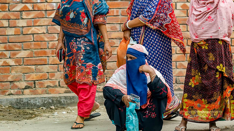 A woman waits for a TCB truck to arrive at Hatirjheel’s Madhubagh.
