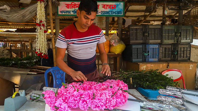 A florist spends a busy day making garlands for Victory Day celebrations.