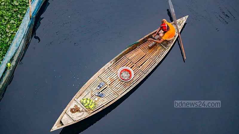 A man catches fish using an illegal China net on the Dhaleshwari River.