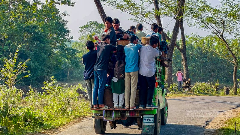 Some passengers sit on the roof of a Chander Gari vehicle in the hilly district of Khagrachhari, while others stand on the step at the back, holding onto the rails or the roof.