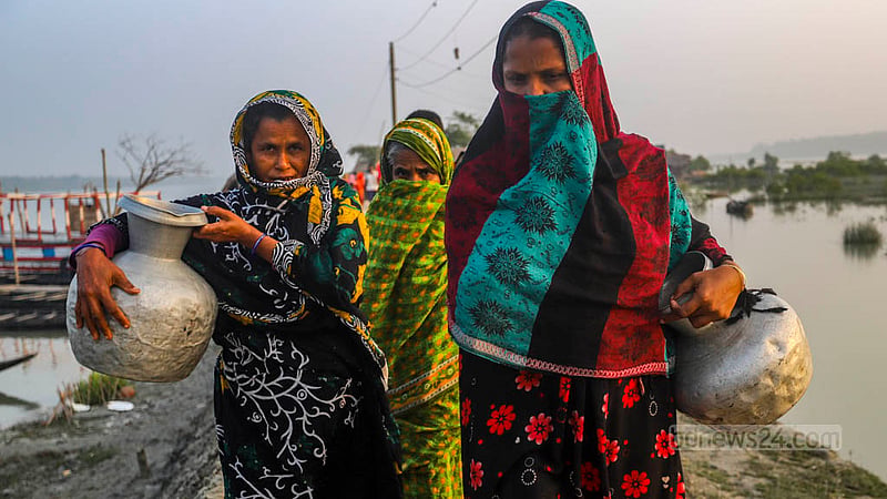 The women of Jhulonto Para in Dakop’s Kalabogi carry jugs to ponds to collect water. Once the water they stored in the monsoon runs out, the pond becomes their only source of freshwater throughout the winter.