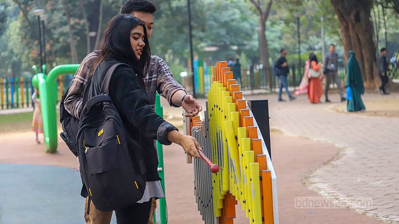 Young people play the xylophone in the Children's Corner of Dhaka's Ramana Park.