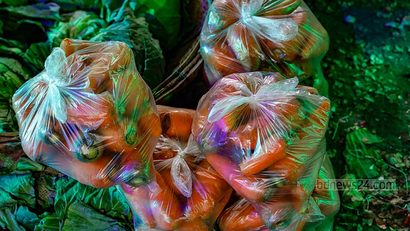 Customers receive carrots, among other vegetables, packaged in polythene bags in Dhaka's Karwan Bazar.