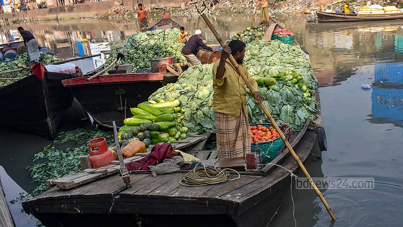 Boatmen bring their vessels near the banks of the Chaktai canal to offload winter vegetables.