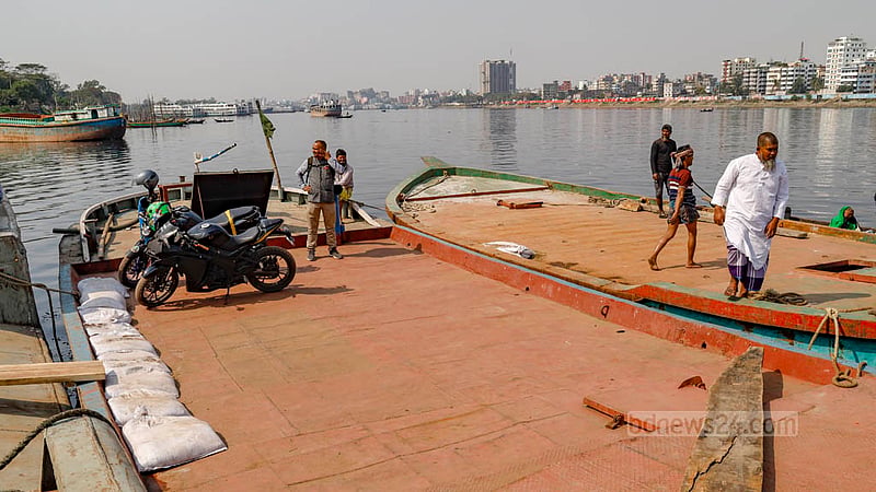 Motorcyclists cross the Buriganga River by boat because the Postogola Bridge is completely closed or sometimes partially open for repair works.