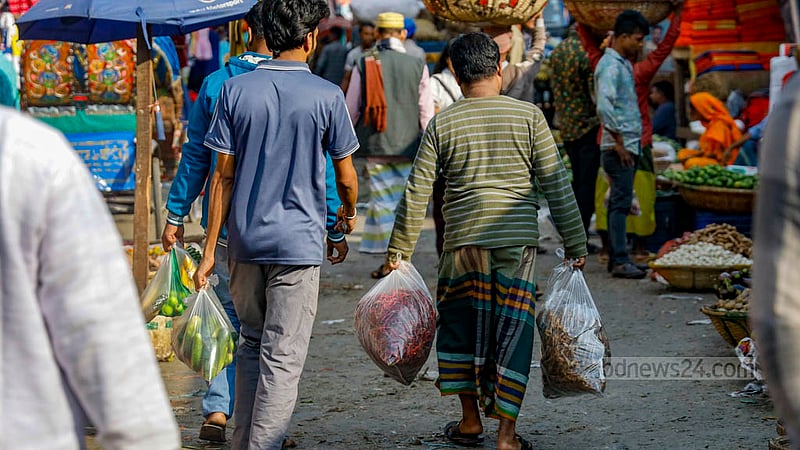 A man is seen carrying products in polythene bags from Dhaka's Karwan Bazar.