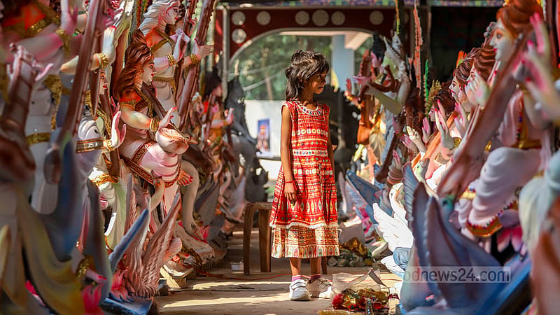 A child watches idols of Hindu goddess Saraswati at Ramna Kali Temple in Dhaka.