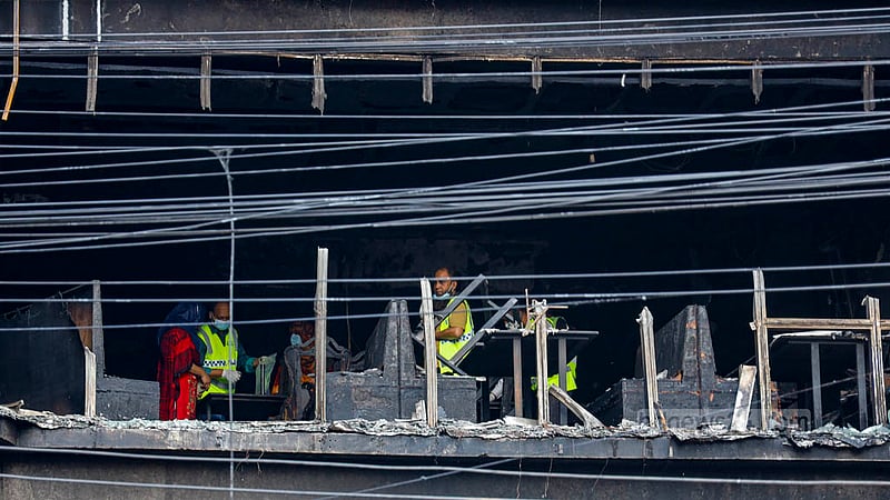 Officials of police’s Criminal Investigation Department gather evidence from the rubbles of the Green Cozy Cottage building on Bailey Road in Dhaka.