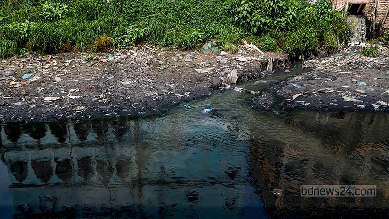 A layer of plastic garbage surfaces on the mud along the pitch black water of the Buriganga River on World Water Day on Friday, Mar 22, 2024.