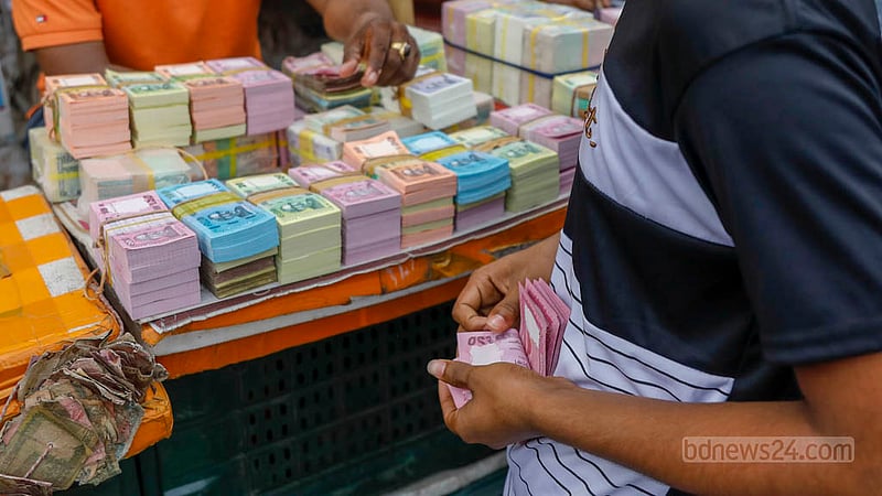 A customer counts new currency notes being sold on the footpath of Gulistan before Eid-ul-Fitr.