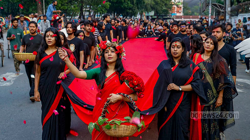 An artist of theatre group Prachyanat, dressed in a red saree, plays the mother’s role in their street drama ‘Laljatra’ at the Swoparjito Swadhinata Chattar of Dhaka University on Monday, remembering the martyrs of the dark night of Mar 25, 1971.