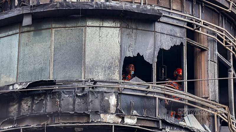 Fire Service personnel inspect the debris of Green Cozy Cottage after a fire gutted the building on Dhaka's Bailey Road on Thursday night, Feb 29, 2024.