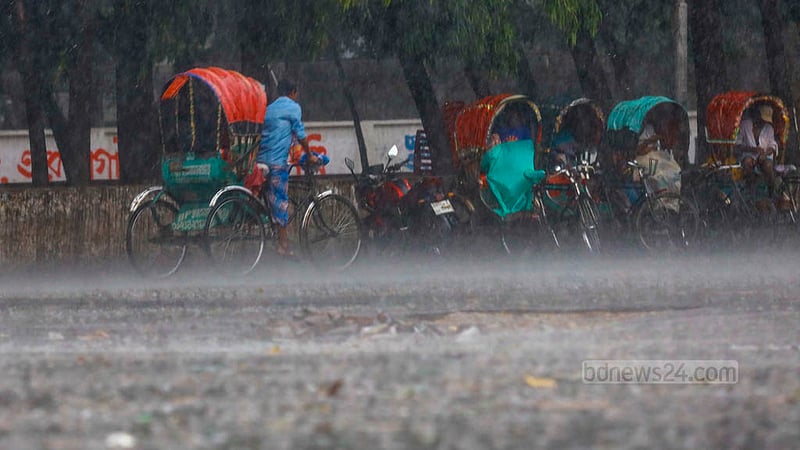 A rickshaw-puller covers himself with a polythene sheet while another pedals through rain in the TSC area of Dhaka University on Tuesday, Apr 16, 2024.