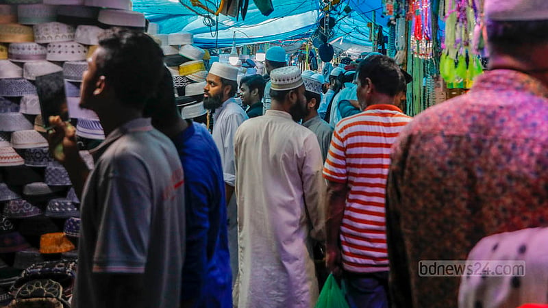 Customers crowd stores in front of the Baitul Mukarram National Mosque to buy caps ahead of Eid-ul-Fitr.