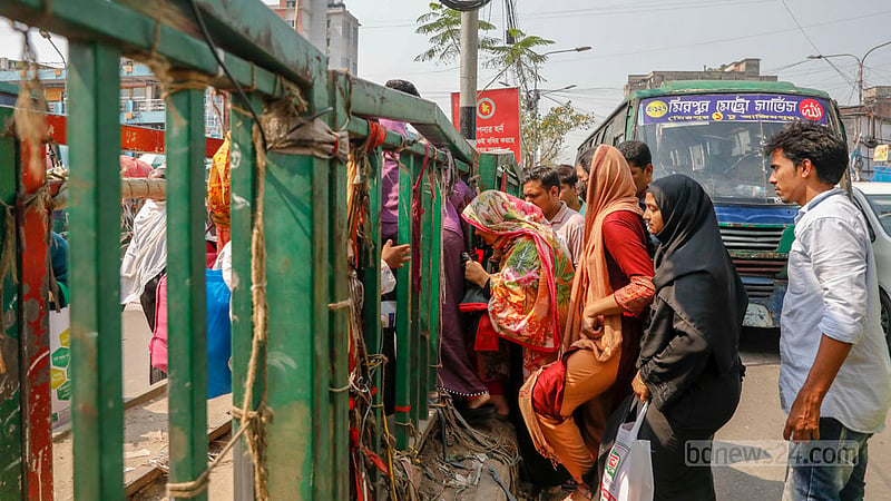 Many pedestrians take the road divider to cross the road despite risk due to the lack of a footbridge outside Dhaka’s New Market.