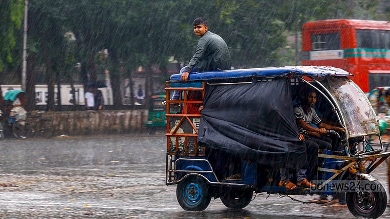 A man on the roof of an autorickshaw enjoys rain amid a heatwave in the TSC area of Dhaka University on Tuesday, Apr 16, 2024.