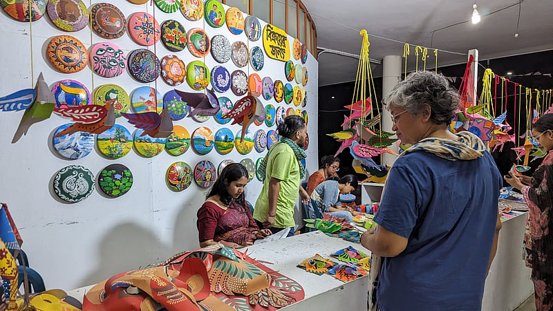 Guests browse through bowls, masks, and other items put on display and for sale at the Dhaka University Faculty of Fine Art amid preparations for the Mangal Shobhajatra procession.