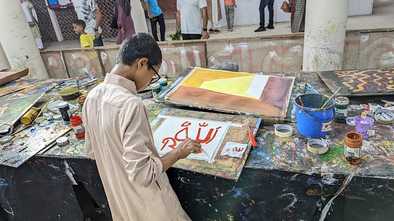 A young man paints at the Dhaka University Faculty of Fine Art amid preparations for the Mangal Shobhajatra procession.