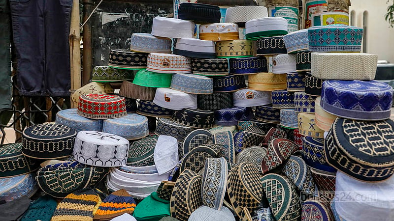 Caps are displayed for sale at a store in front of the Baitul Mukarram National Mosque.