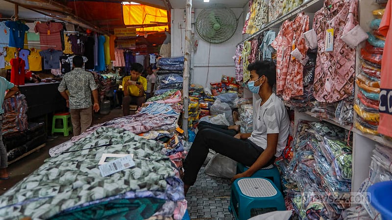 Traders at the Bangabazar market sit idle as hardly any buyers are visiting the shops.