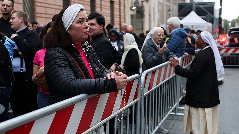 A woman looks on as the faithful queue to enter St Peter's Basilica to pay respect as Pope Francis lies in state, as seen from Rome, Italy, Apr 24, 2025. REUTERS