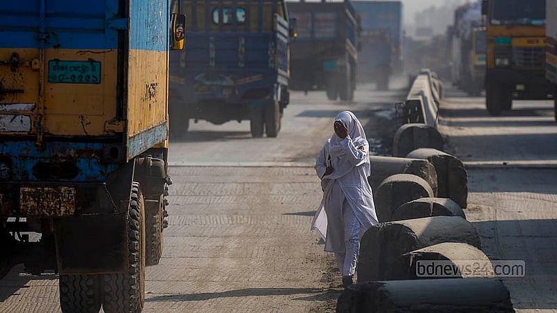 The Dhaka-Sylhet Highway in Narayanganj's Rupganj is engulfed with dust. Pedestrians cross the road while covering their faces.  Photo: Mahmud Zaman Ovi
