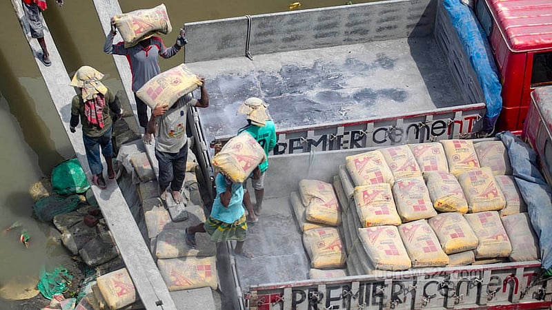 Cement is unloaded from barges and loaded onto trucks under Dhaleshwari Bridge No. 1 in Keraniganj. From there, the shipments are sent to nearby districts. Photo: Abdullah Al Momin