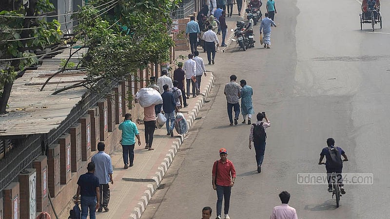 Commuters walk to their destinations on Monday, Mar 10, 2025, after traffic was halted at Chairman Bari U-turn in Banani, where garment workers blocked the road following the death of a female colleague in a road accident. Photo: Abdullah al Momin
