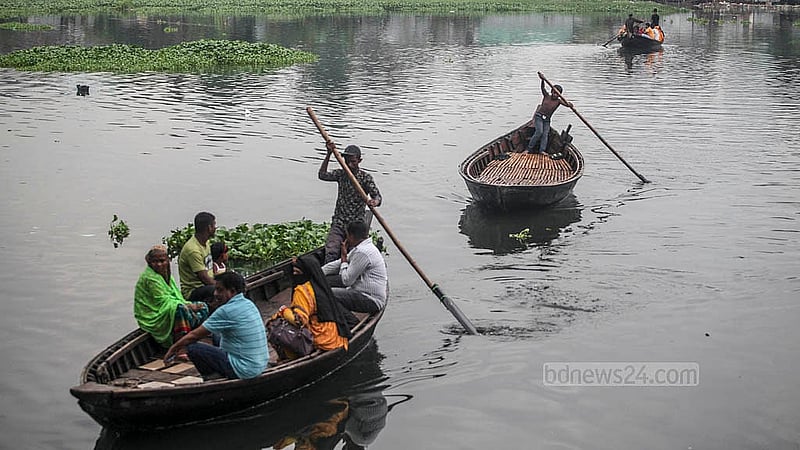 A child rows the boat  as families travel by boat to Korail slum in Dhaka. Photo: Abdullah Al Momin