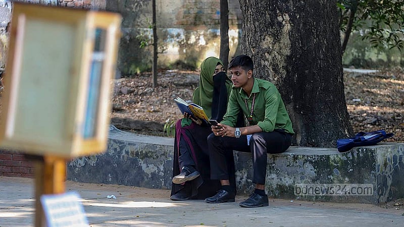 Students visiting Dhanmondi Lake read books from bookcases. After reading, they must leave the books in their original places. Photo: Abdullah al Momin