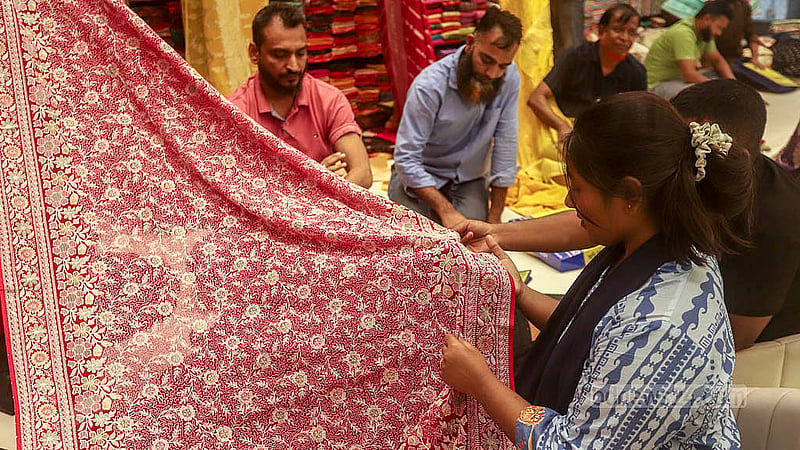Customers crowd a store at Benarasi Palli in Dhaka’s Mirpur. The buyers browse the selections and haggle before making their purchases for Eid. Photo: Abdullah al Momin