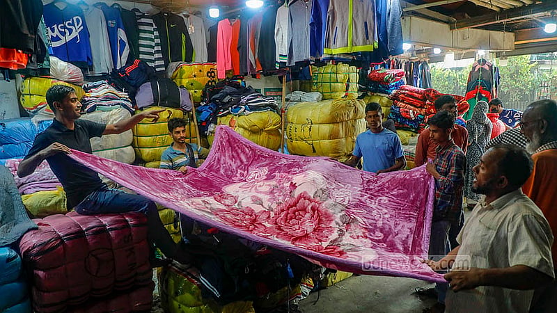 A potential customer browses among old foreign blankets on display at the Sadarghat wholesale market in Old Dhaka. Depending on the quality and size, they sell for Tk 300-4,000. Photo: Abdullah Al Momin
