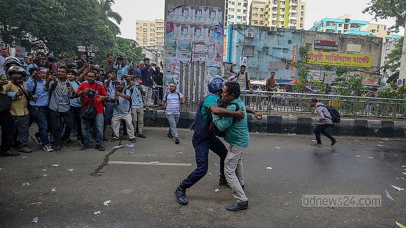 A police officer attempts to remove MPO-listed teachers and employees from the street in front of the National Press Club on Sunday afternoon, Oct 12, 2025.
