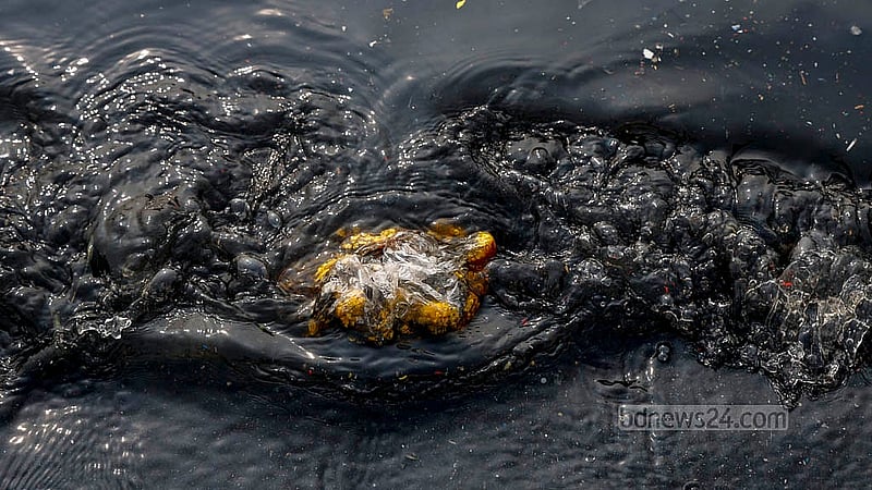 Waste materials float in the black water of the Buriganga River, looking like a painting done on black canvas. Photo: Mahmud Zaman Ovi